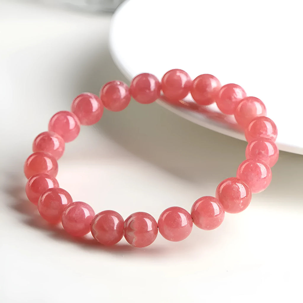 Close-up of a women's geometric red crystal bracelet with a longevity lock on a wrist.