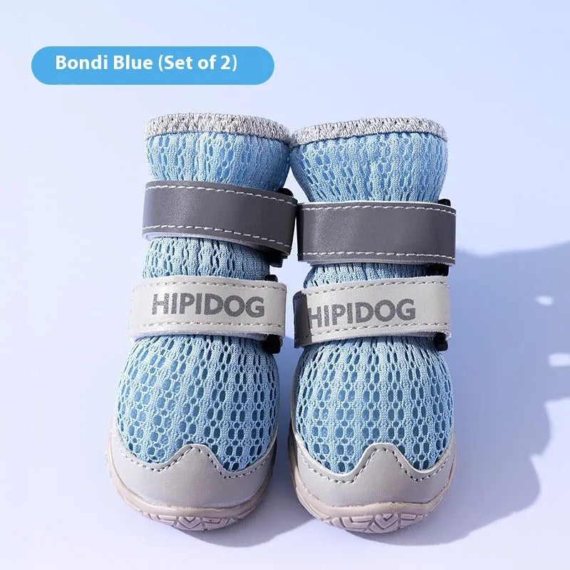Pair of light blue breathable dog shoes with mesh upper and PU sole on a wooden surface.