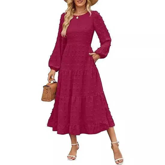 A woman wearing a beige high-waist long sleeve dress with ruffle detailing on the sleeves.
