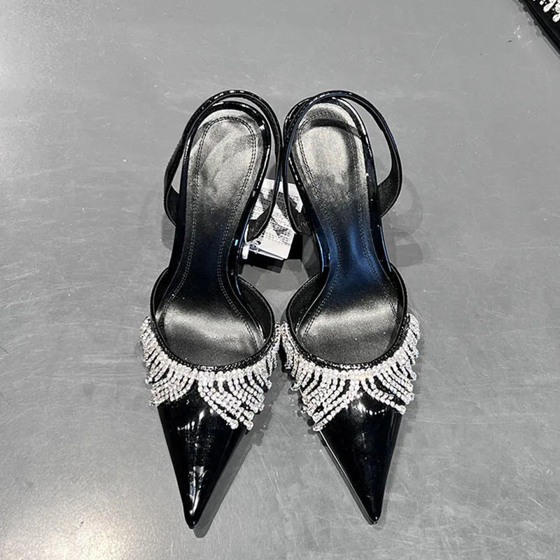 Black high heel sandals with rhinestone tassel decoration, pointed toe, and slingback strap showing 10cm stiletto heel