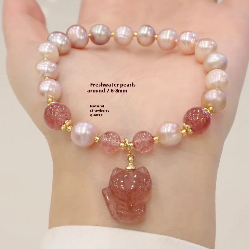 Women's light pink freshwater pearl and strawberry quartz bracelet with a silver fox charm on an adjustable chain.