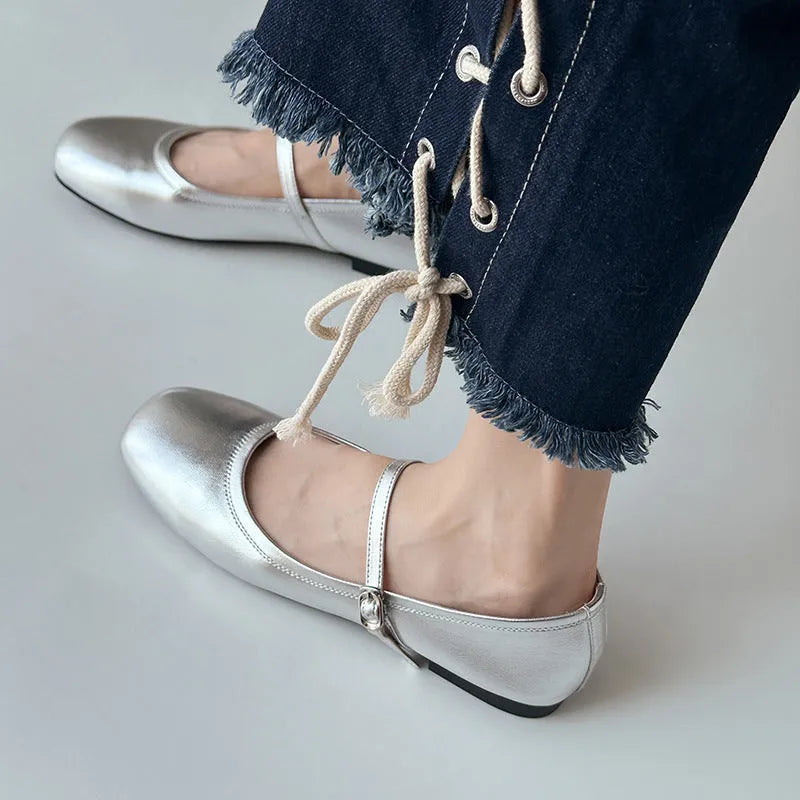 Women's black sheepskin Mary Jane flat shoes with round toe and flat rubber sole on a white background.