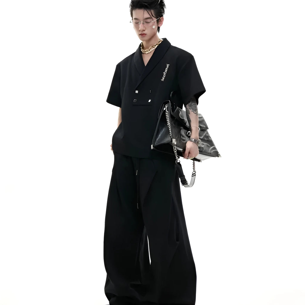Men's dark grey padded shoulder metal embellished V-neck sports suit with short sleeves and matching shorts.