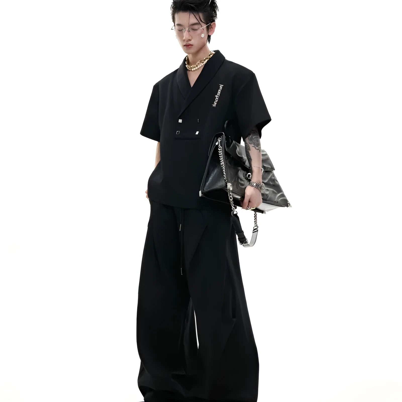 Men's dark grey V-neck padded shoulder short sleeve jacket with metal embellishments and matching shorts.