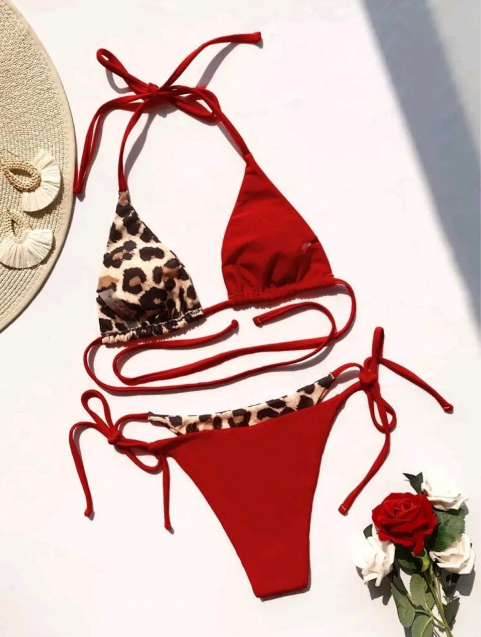Women's red leopard print bikini with halter neck lace-up top and high-waisted bottoms.