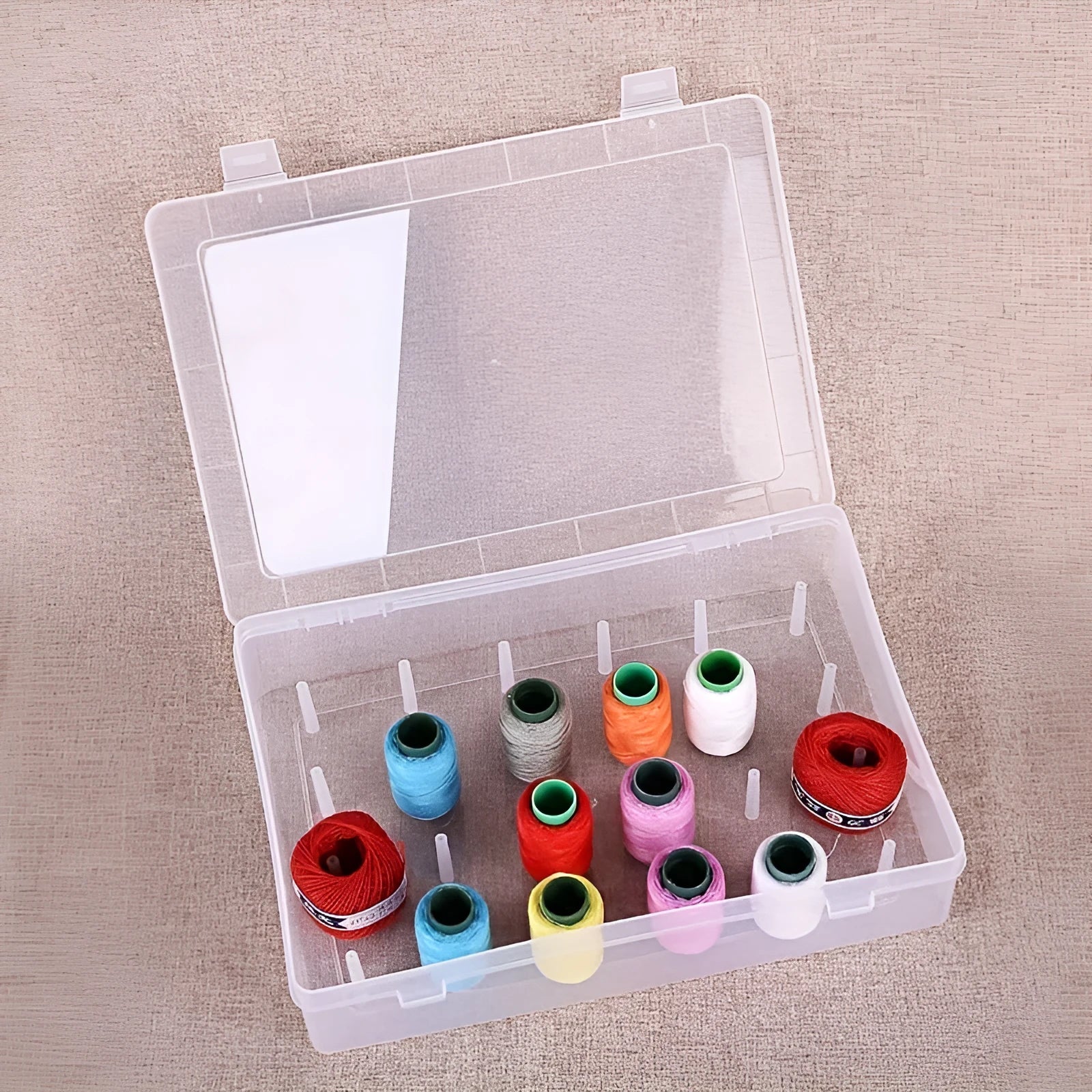 Plastic storage box with 42 compartments for organising embroidery threads and sewing kit accessories.