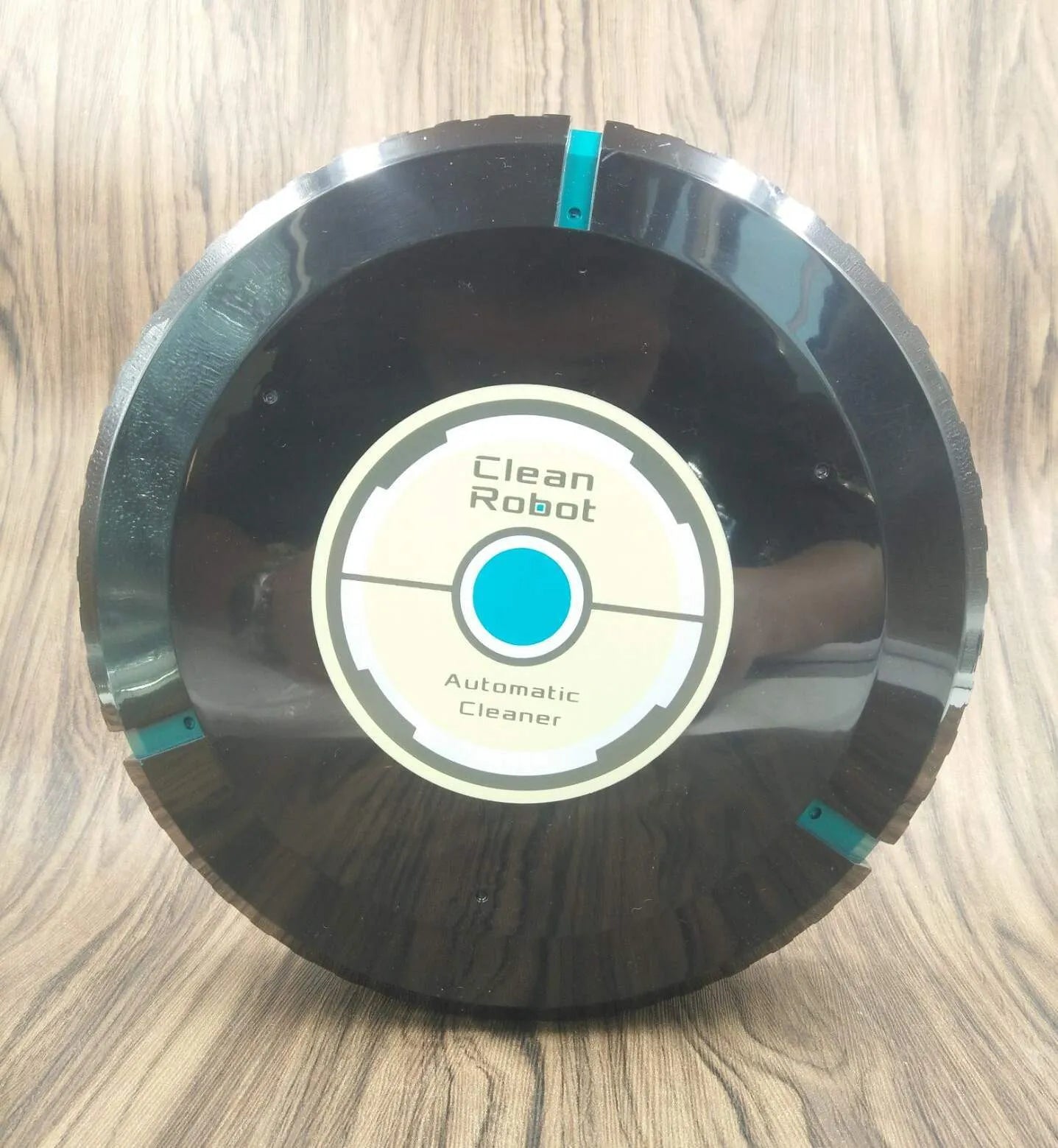 Black or white AC automatic sweeping robot vacuum cleaner on a hard floor.