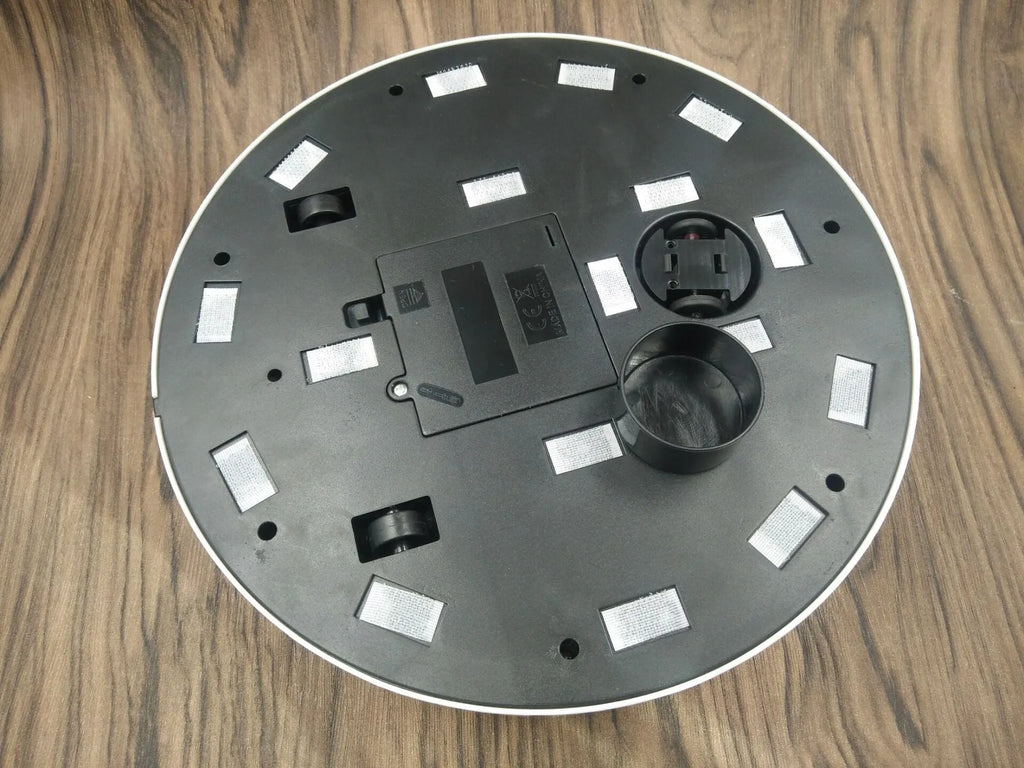 Black or white AC automatic sweeping robot vacuum cleaner on a hard floor.