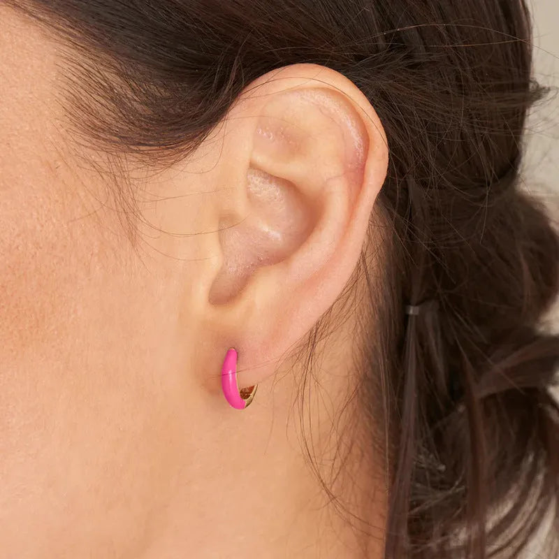 A pair of curved U-shaped epoxy earrings with a translucent blue dripped oil finish and a silver hook on a white background.