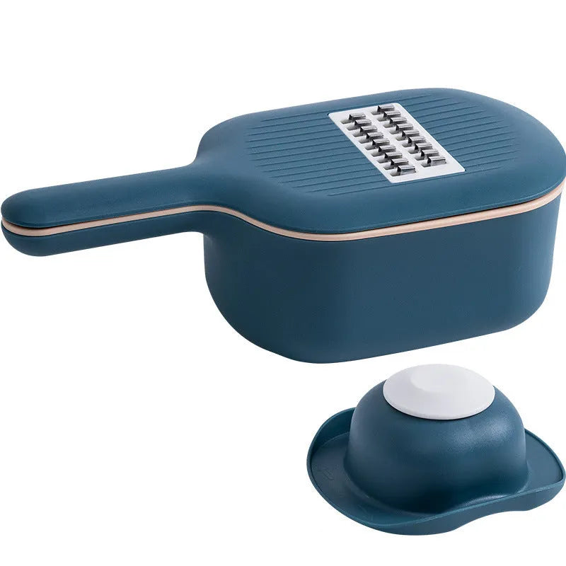 Dark blue manual vegetable cutter with four blades, hand guard, and drain basket on a kitchen counter