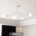 Minimalist black iron ceiling chandelier with six light heads in a Nordic style, against a white background.