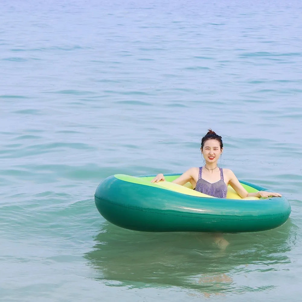 Green avocado-shaped inflatable pool float measuring 169cm long on blue water