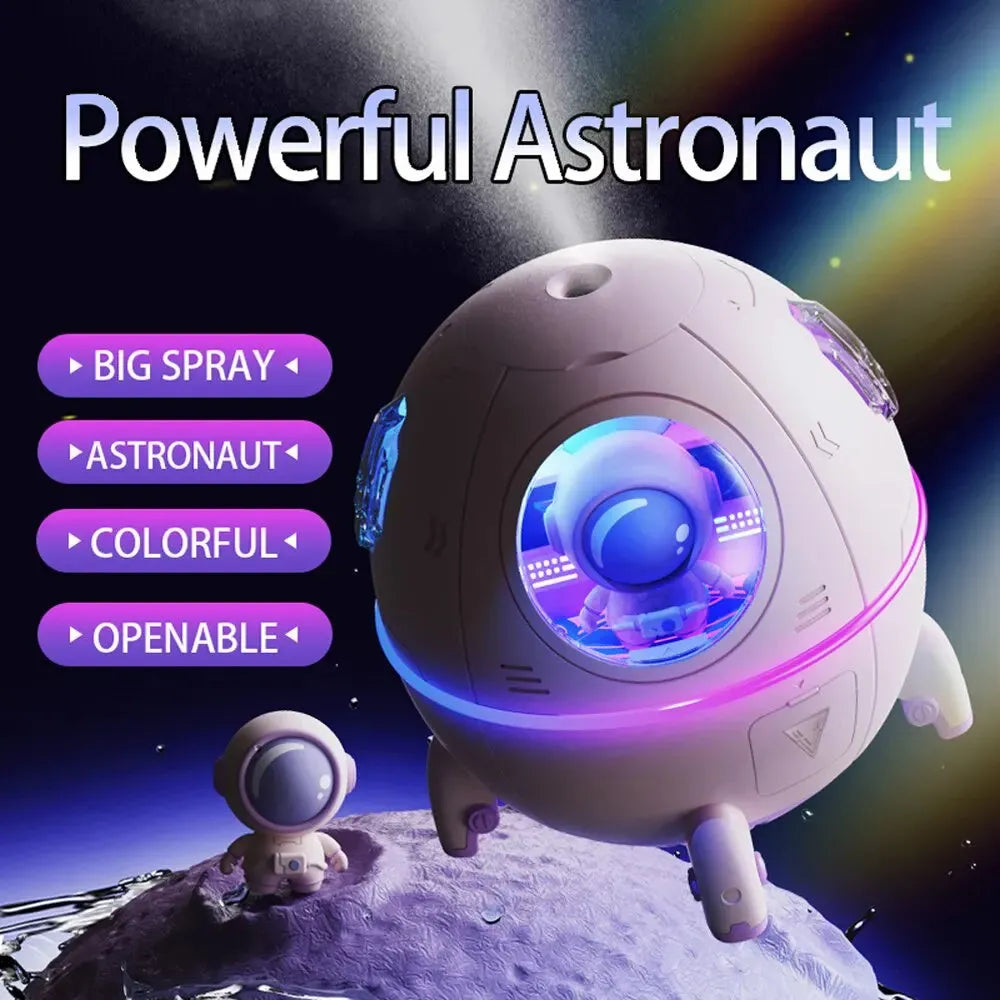 Astronaut-themed portable USB humidifier with blue LED light on a desk next to a laptop.