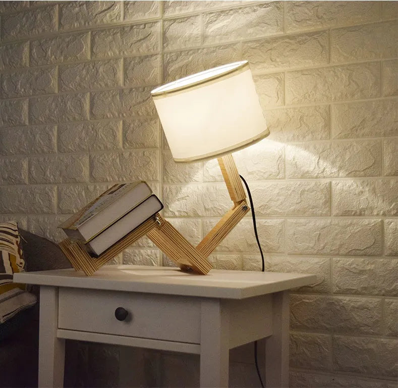 Creative humanoid wooden table lamp with white fabric shade and deformable design on a wooden surface