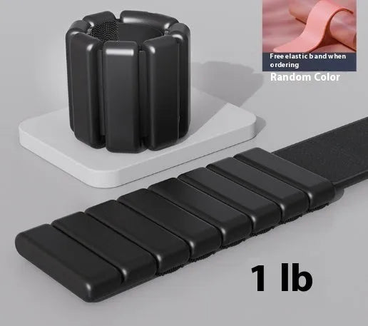 Silicone fitness wrist weight bracelet with Velcro strap in black, shown on a wrist.
