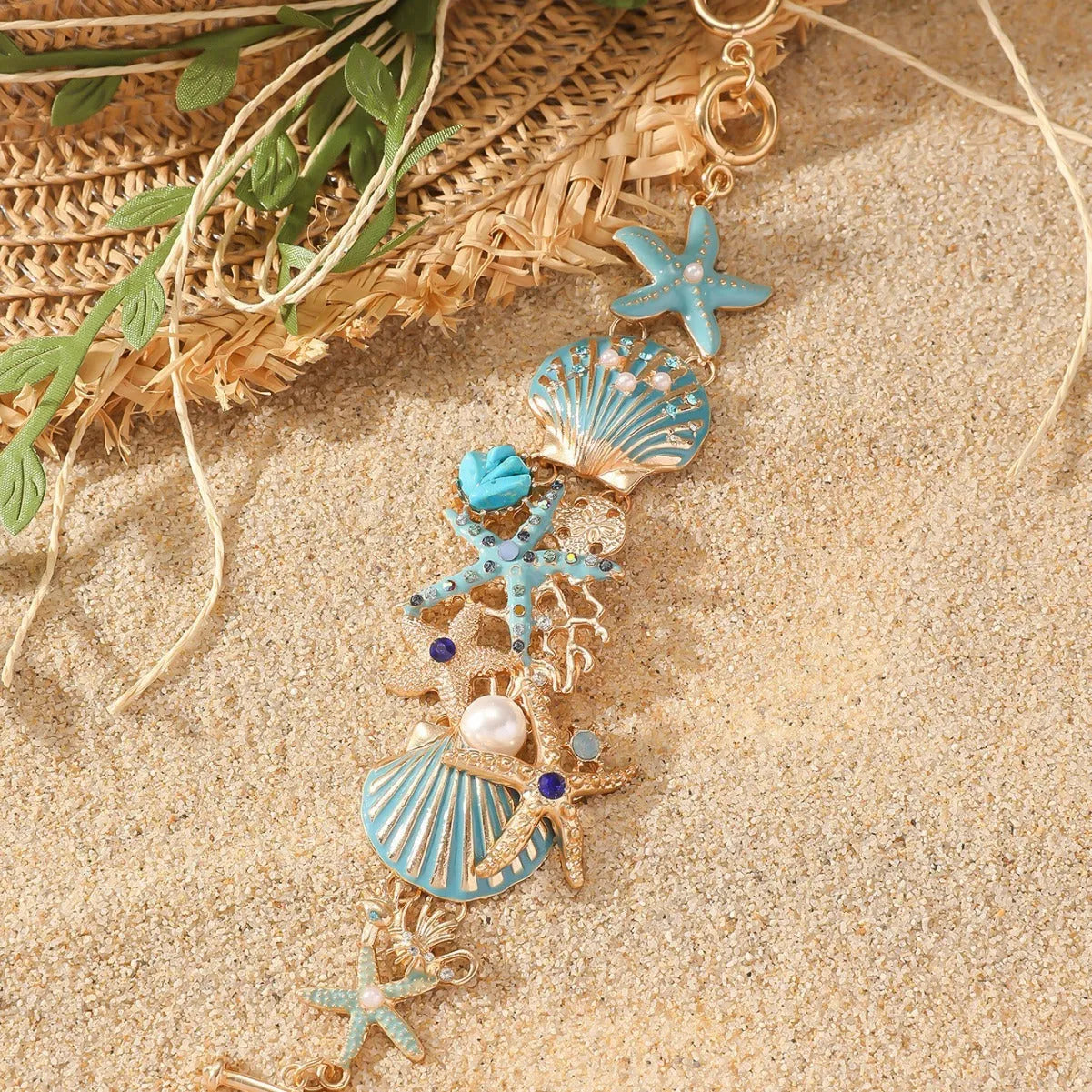 Women's alloy nautical bracelet with boat anchor, shell, and starfish charms in turquoise, red, or blue.