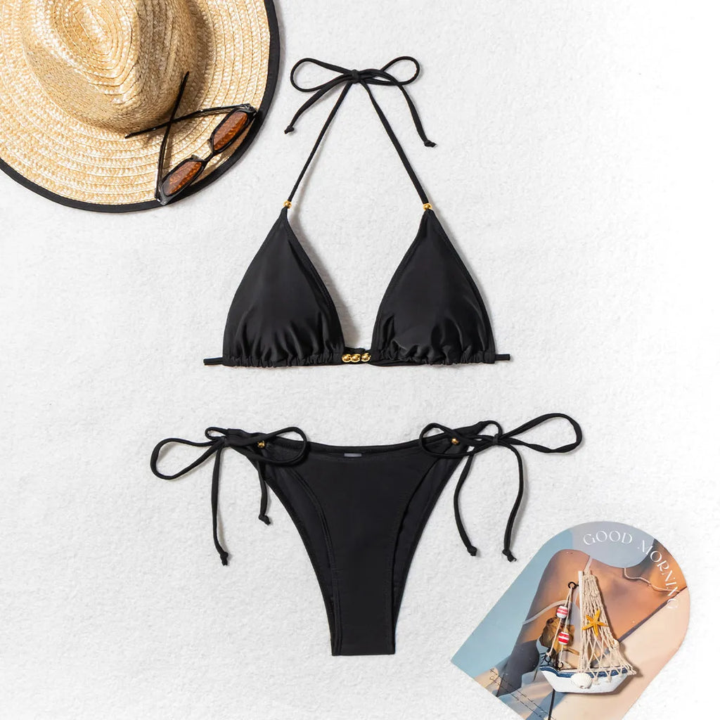 Black women's bikini swimsuit with metal bead decoration on the fabric.