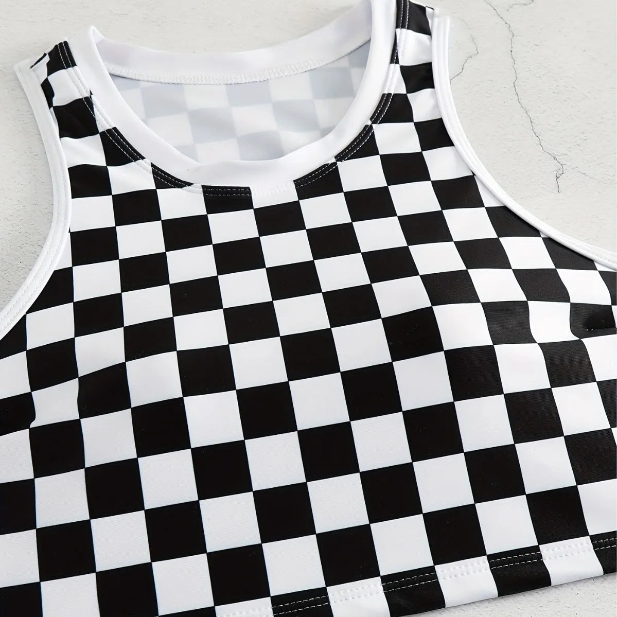 Adult female backless racing swimsuit with suspender straps in checkerboard print pattern