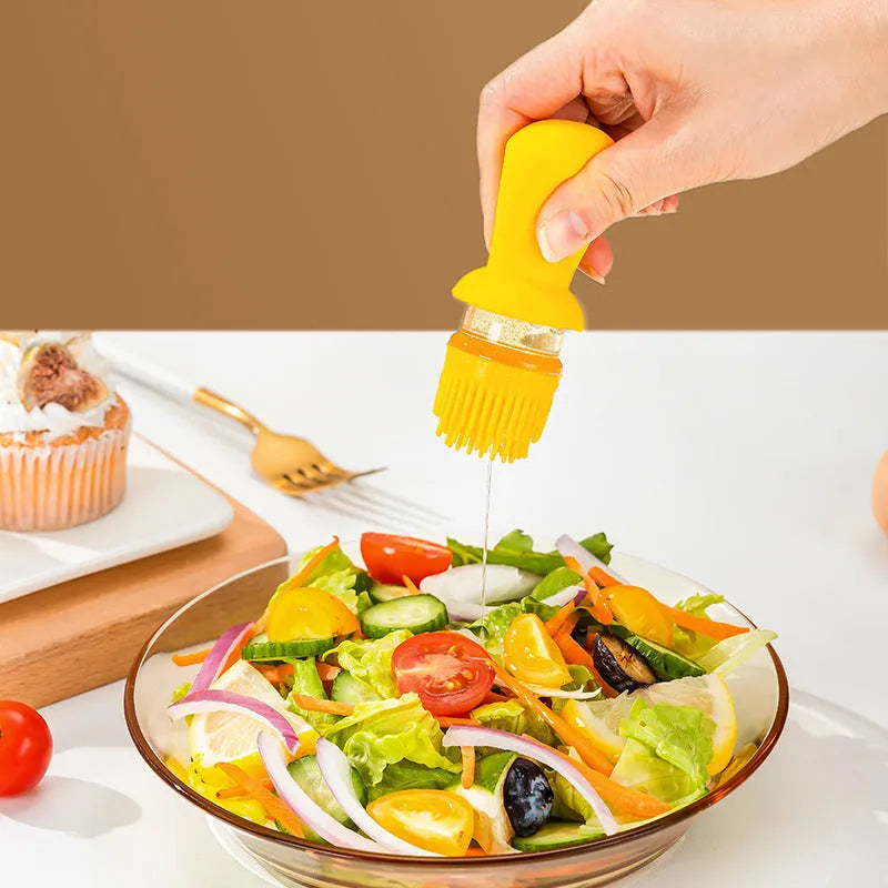 550ml clear glass oil dispenser bottle with stainless steel spray nozzle and a yellow silicone brush head attached.