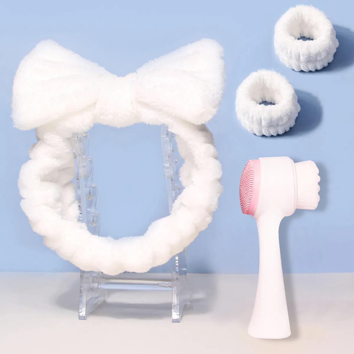 Three-piece facial skincare set showing a nylon brush and a coral fleece hair band in purple.