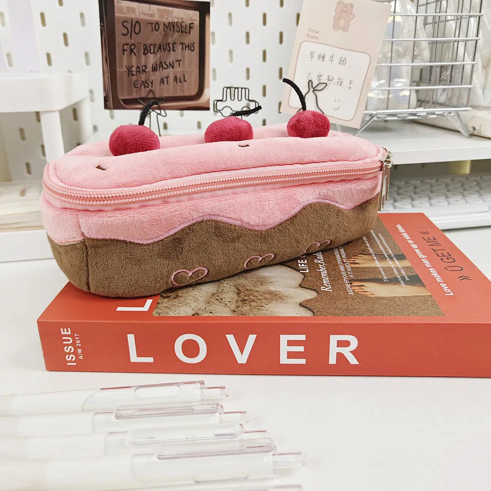 Soft red velvet pencil bag with a cherry cake print and a white zip.