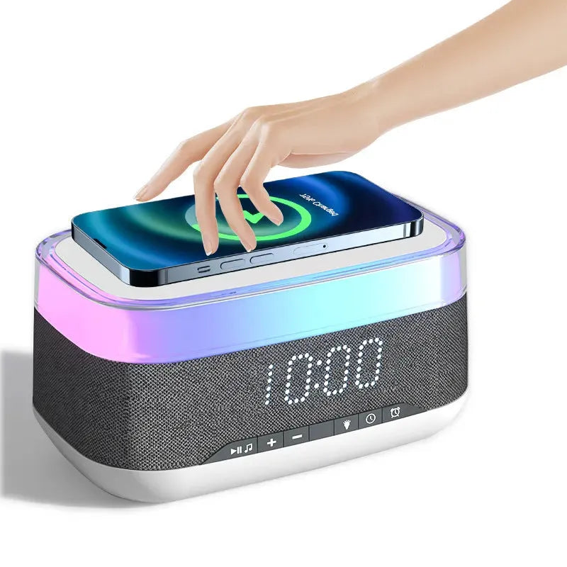 White multifunctional alarm clock with Bluetooth speaker and wireless charging pad on wooden table