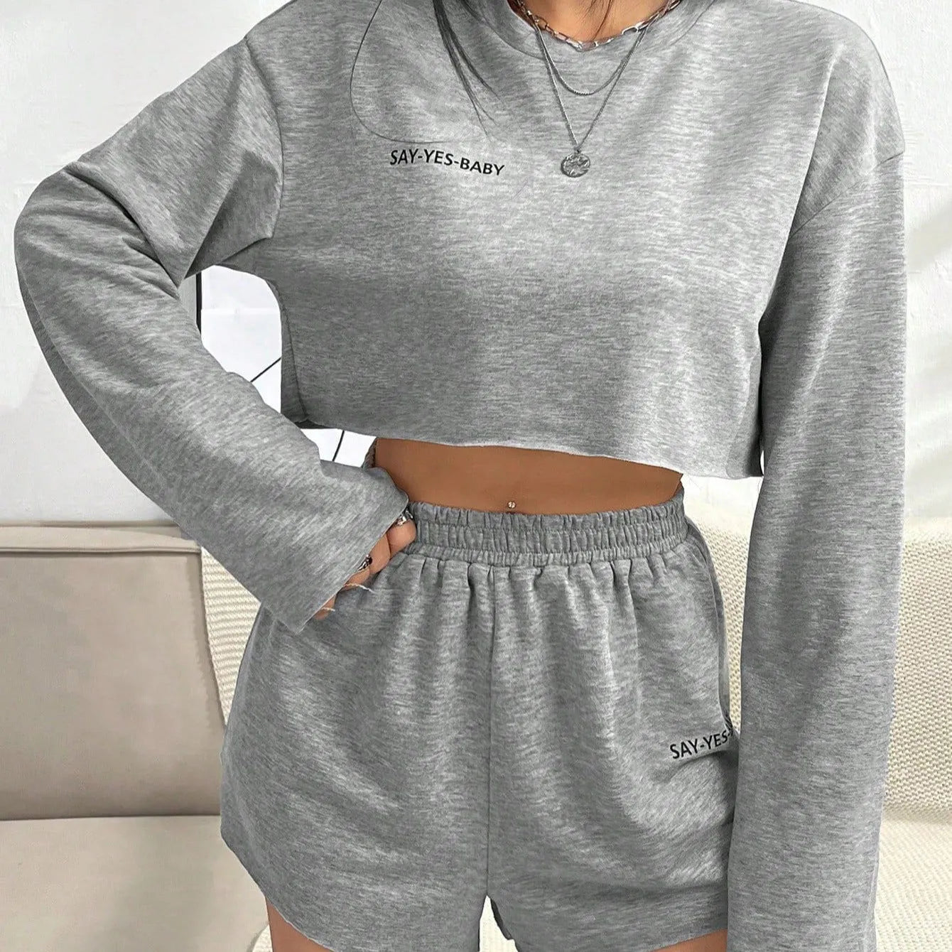 Grey women's long-sleeved t-shirt and matching shorts co-ord set laid flat.