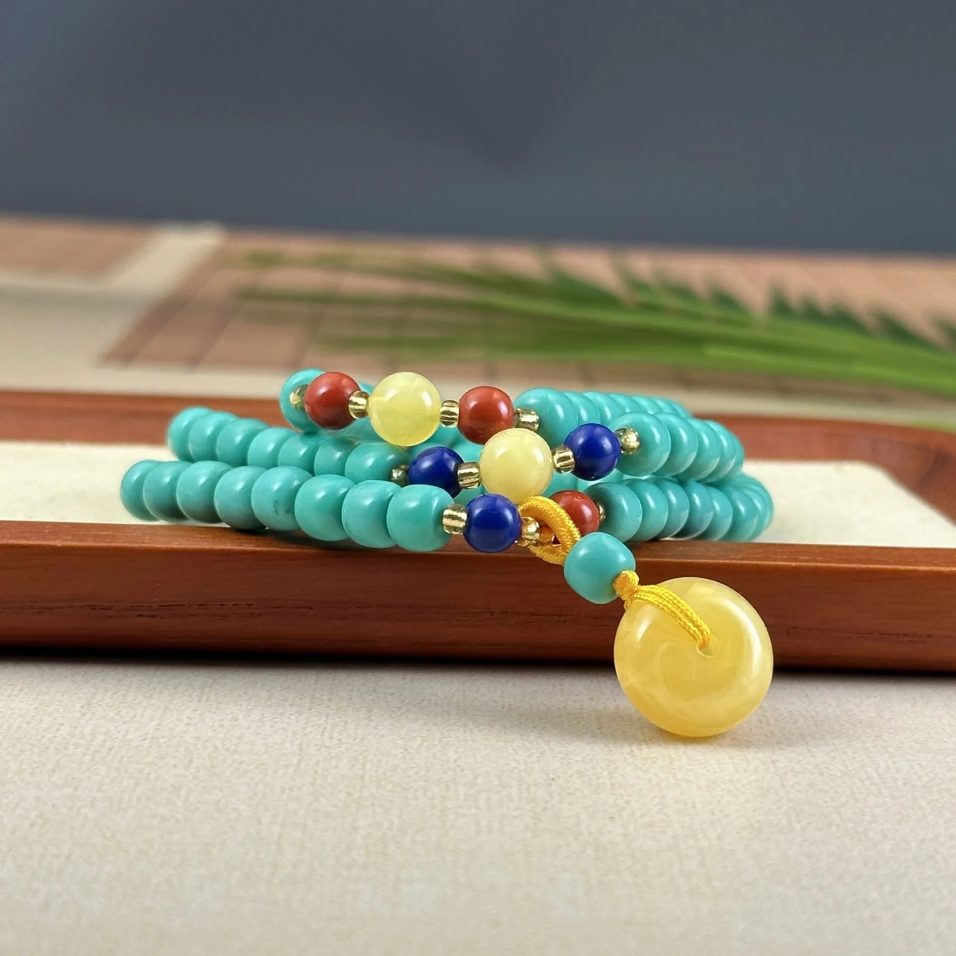 Hand-woven turquoise mesh flower lucky pendant on an adjustable ball bead necklace.