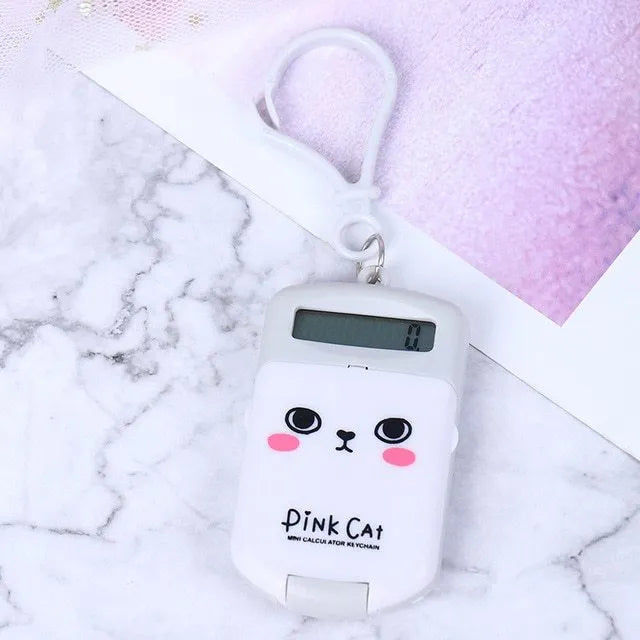 Creative cookie-shaped cute mini calculator in pink with key ring on a white background