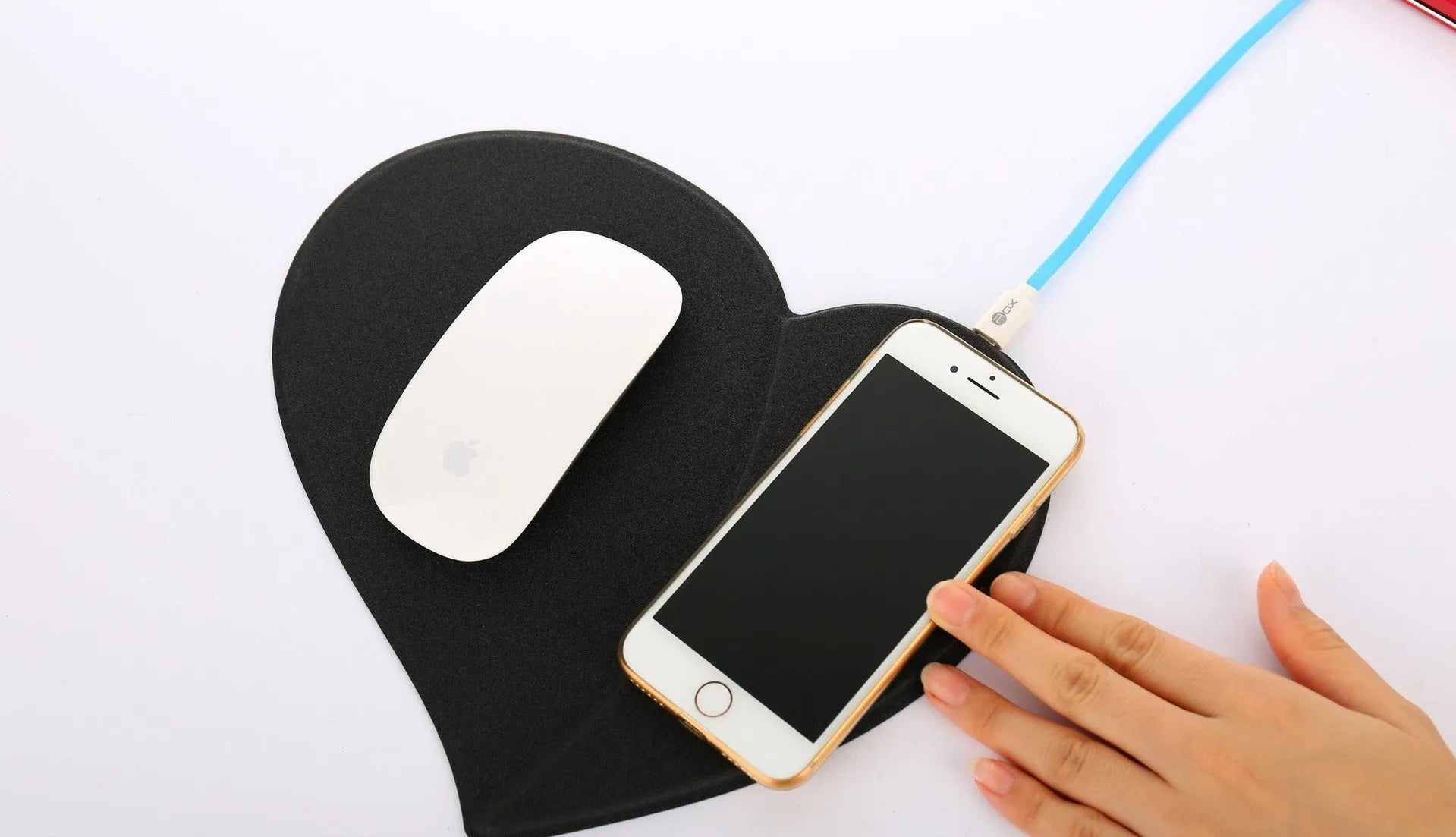 Heart shaped red leather wireless charging mouse pad with indicator light on a desk