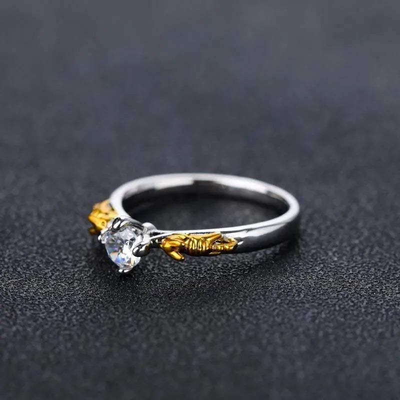 Close-up of a black gold copper ring with a detailed three-dimensional crown design on a finger.