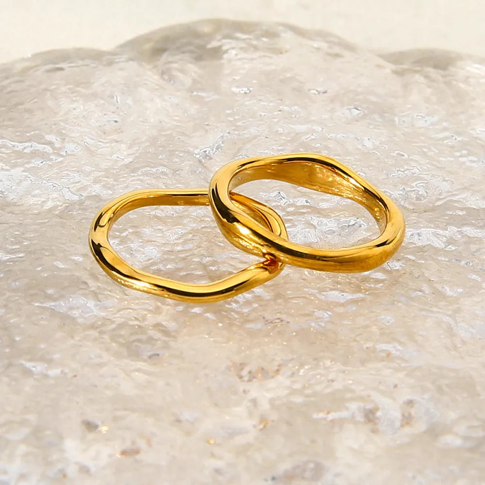 Irregular wave stainless steel ring in colour NXR28 on a plain background, unisex size No 6