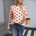 Beige loose fit Maple Leaf Christmas print pullover sweater with contrast details on a hanger.