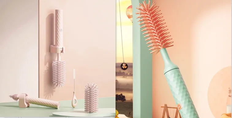 Pink and green electric rotating bottle cleaning brush with silicone bristles on a white background.