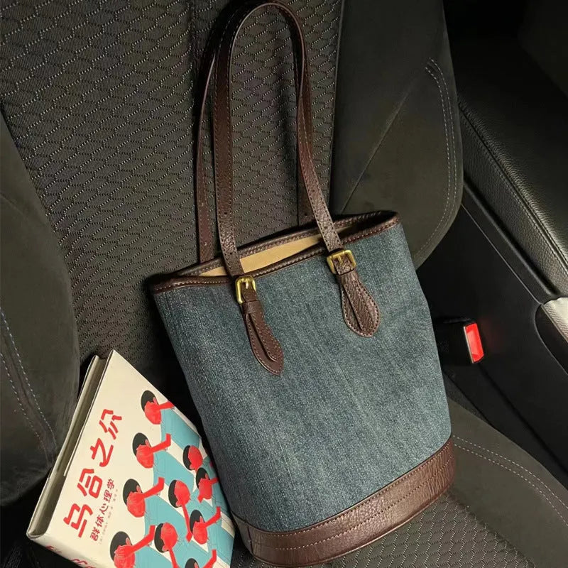 Denim wash patchwork one-shoulder bucket handbag showing front view and strap.