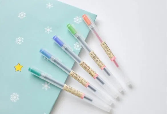 Muji 12-pack of clear barrel gel pens with 0.5mm fine nibs and visible ink, arranged neatly.