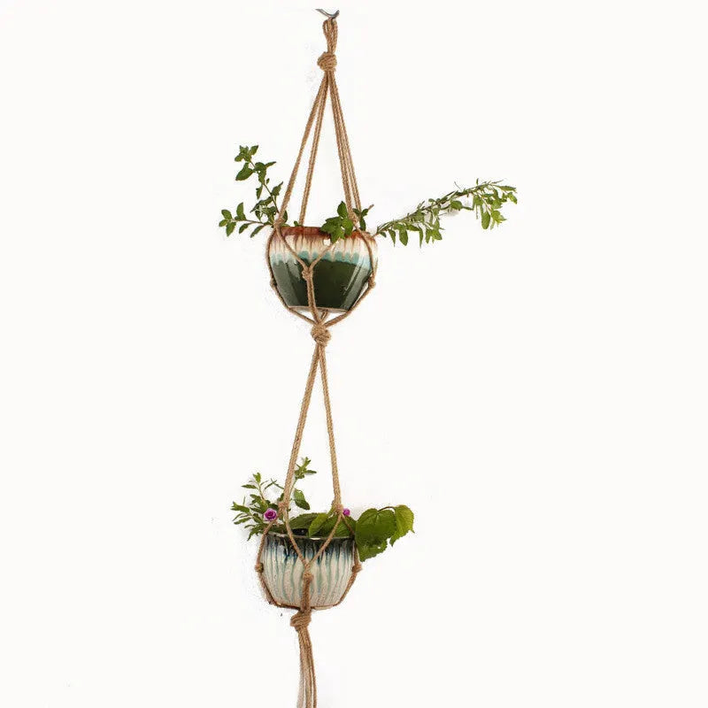 Woven wire plant hanger made from cotton rope in a desktop display style holding a small potted plant.