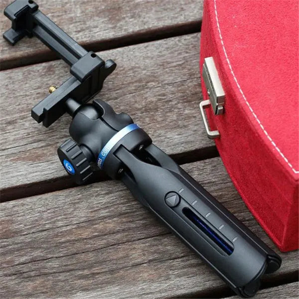 Black plastic and aluminium desktop tripod stand holding a mobile phone.
