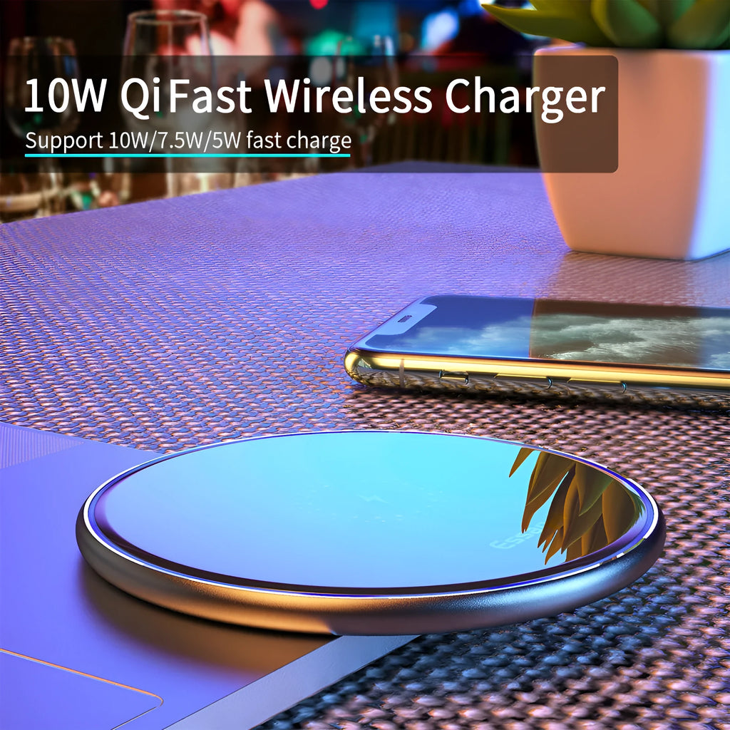 Black aluminium wireless charging pad on a desk with a mobile phone charging on top.