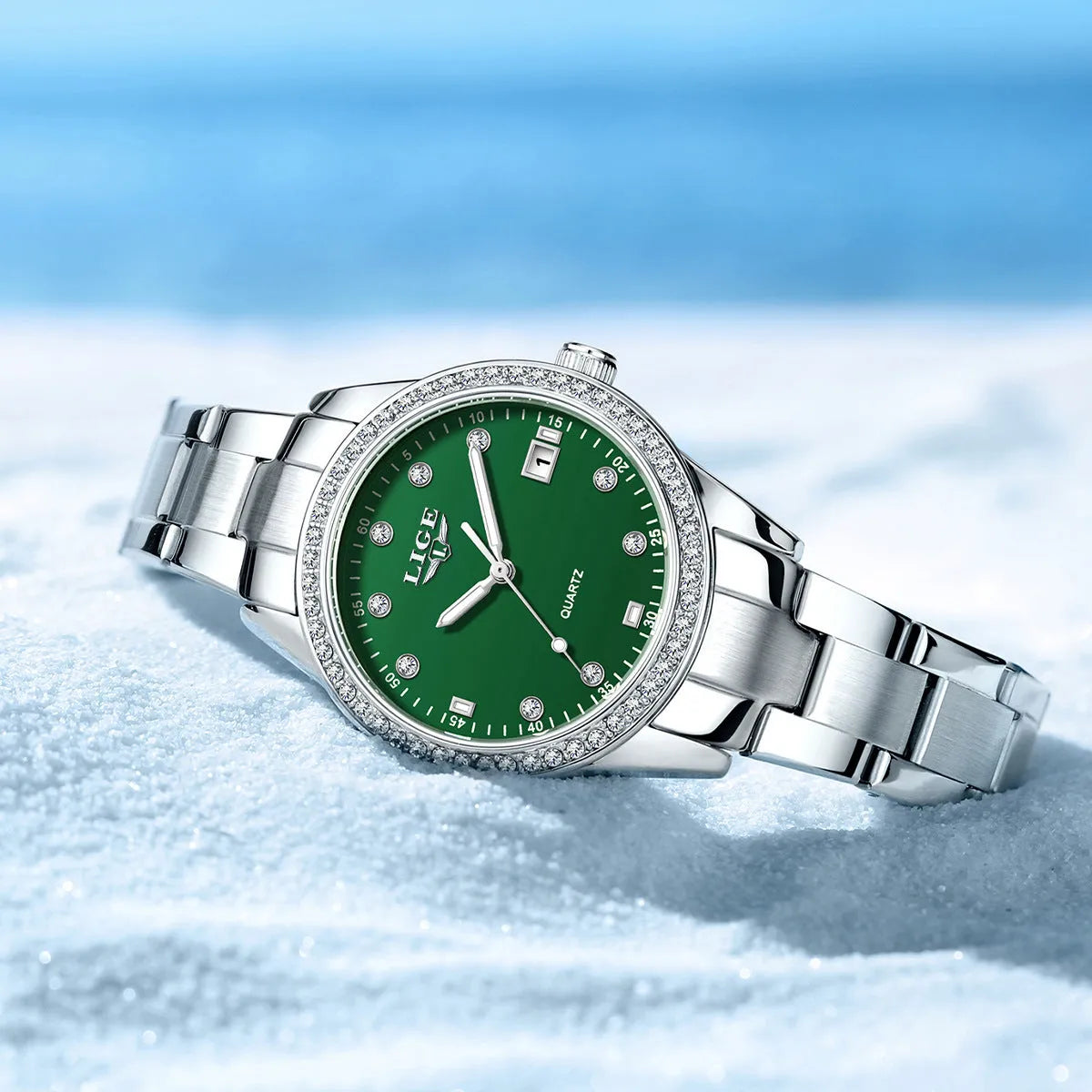 Silver stainless steel women's watch with diamond-encrusted bezel and luminous hands on a 34mm round dial.