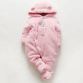 Baby wearing a cotton padded winter jumpsuit with long sleeves, available in marrón, pink, or white colours.