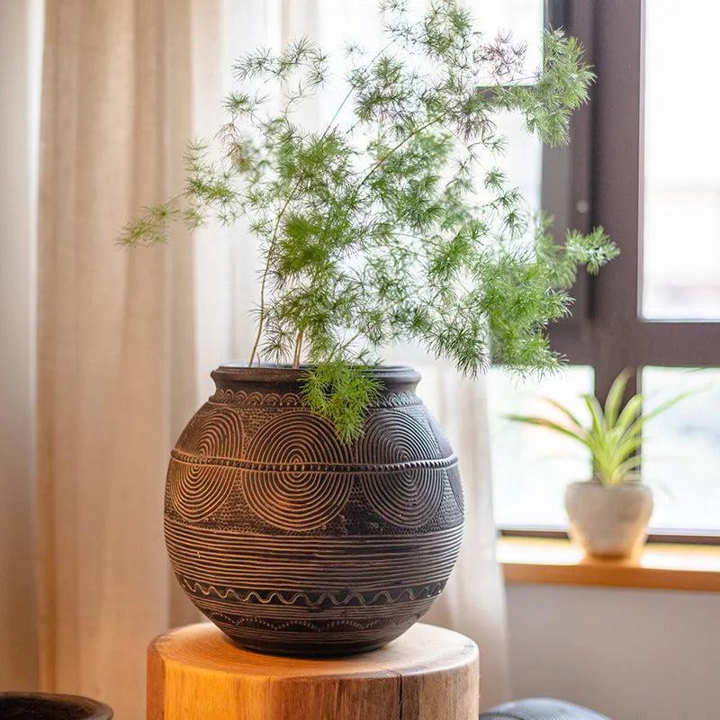 Medium cement flower pot with African ancient tank ethnic design and drainage hole.