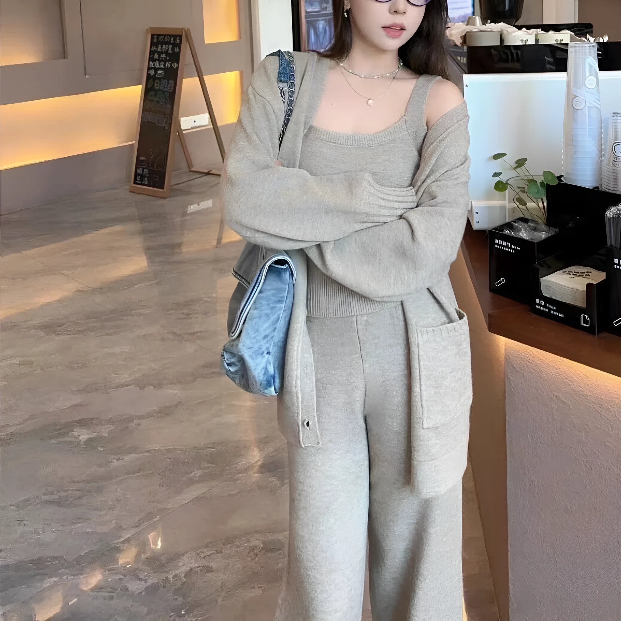 Women's light brown wool blend knit cardigan, vest, and trousers three-piece set laid flat.