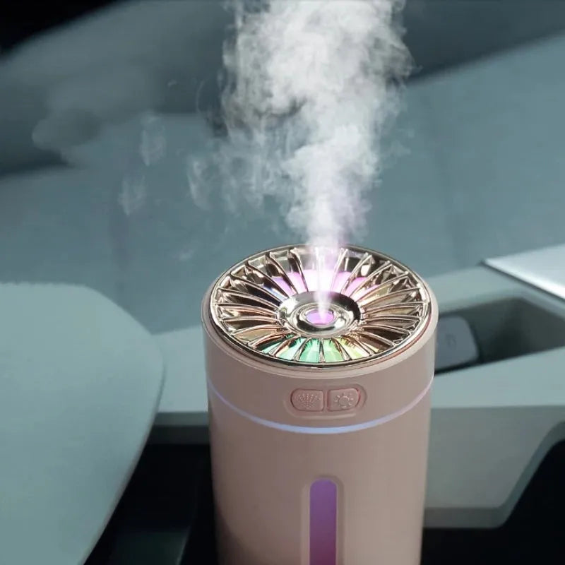 Black wireless USB car humidifier with colourful LED lights on a desktop next to a cup holder.