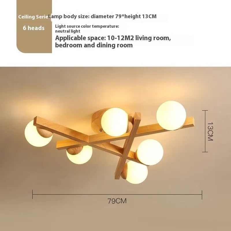 Modern black and copper three-headed pendant ceiling light with adjustable arms hanging over a wooden table