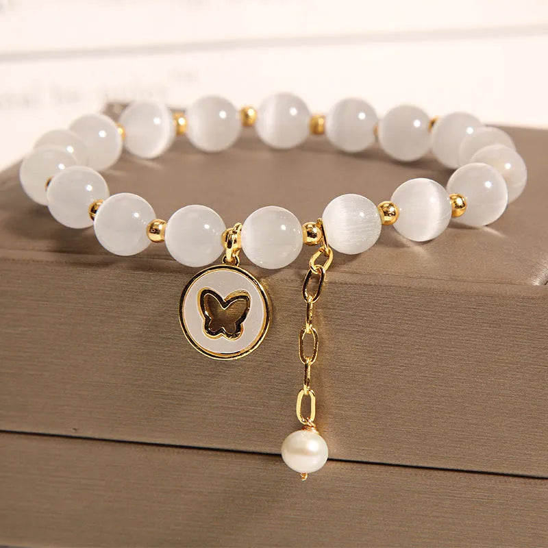 White geometric Cat's Eye crystal bracelet on a wrist, showing its handcrafted Korean-style design.