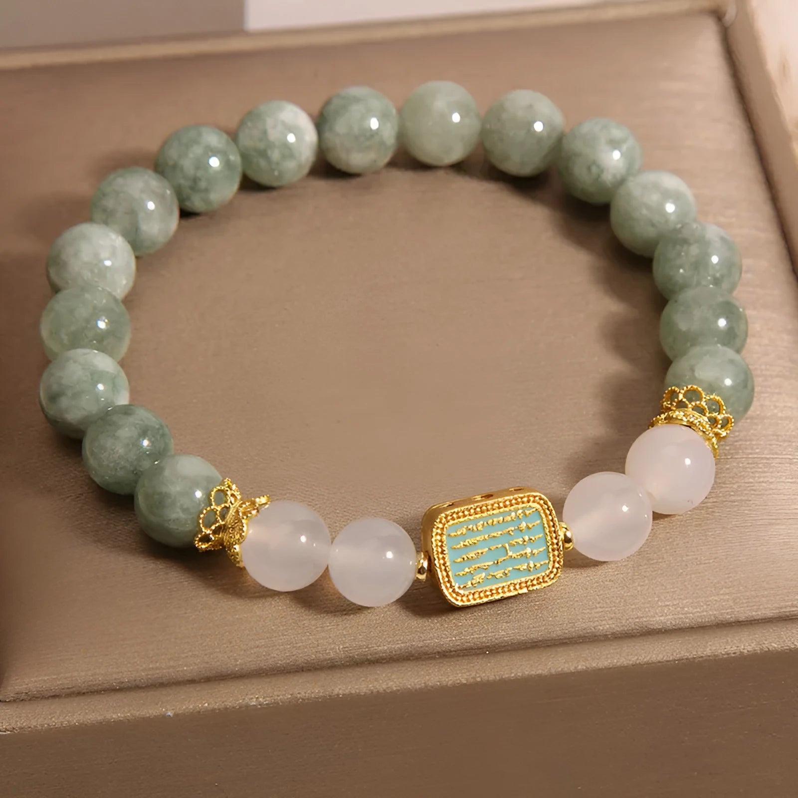 Close-up of a women's oil green emerald crystal bracelet featuring a five-piece sutra design.