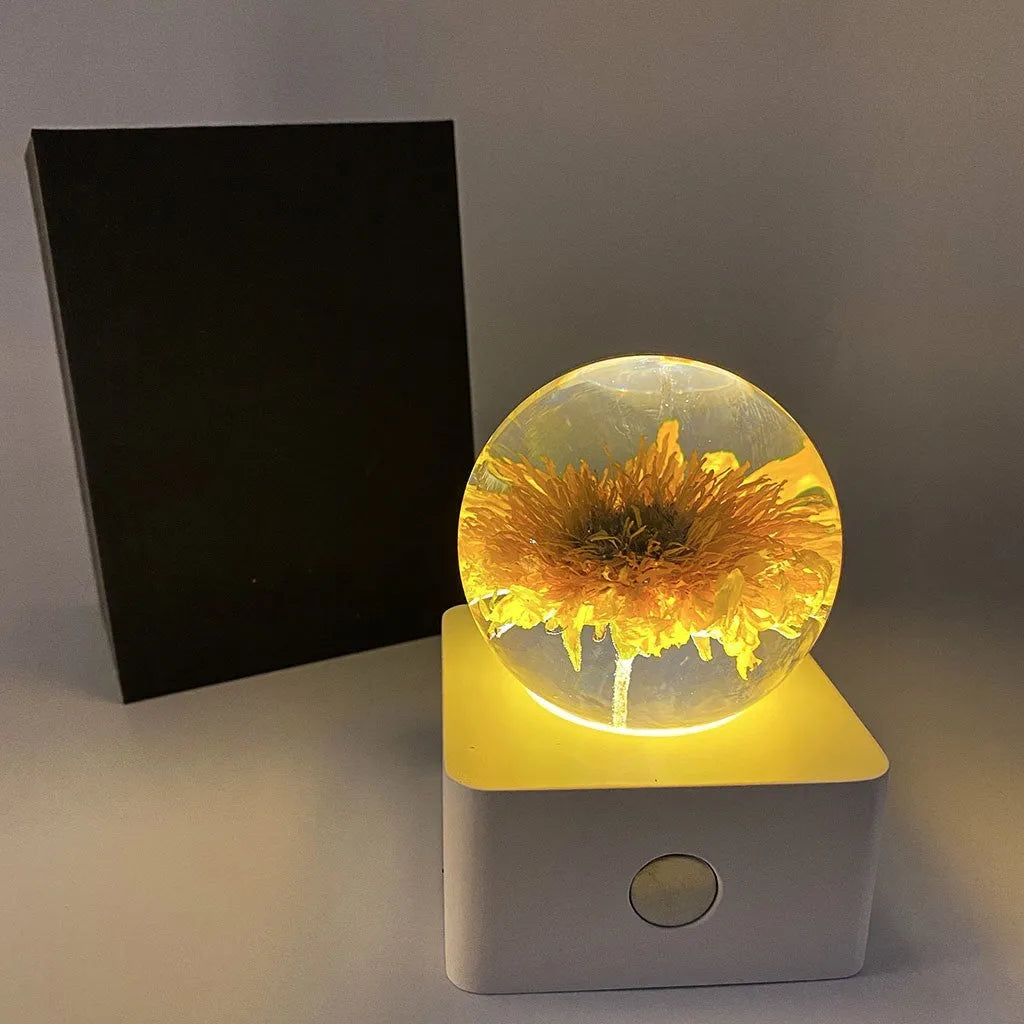 Small 8cm USB night light with a preserved dandelion and sunflower specimen inside, on a desktop.