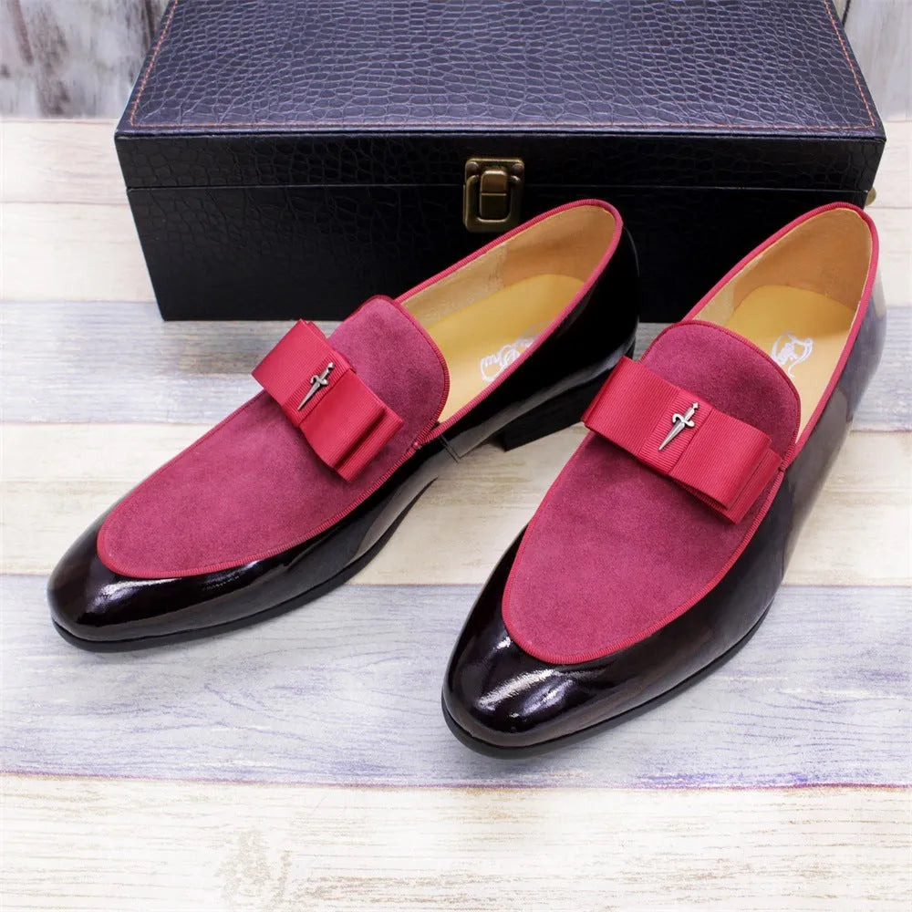 Men's black tassel loafer shoe with matte leather and glossy patent leather detail on a white background.