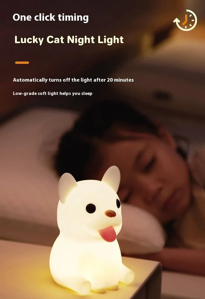 A cartoon bull-shaped silicone USB night light with a dimming function on a bedside table.